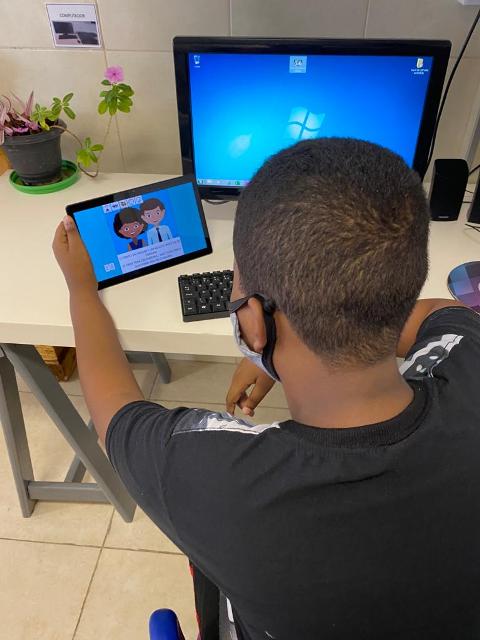menino sentado manuseando vídeo no tablet