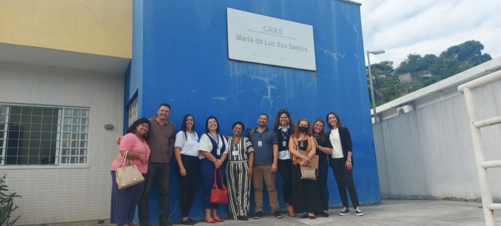 equipe rioinclui com a equipe da cip a frente de uma parede azul. Todos sorridentes