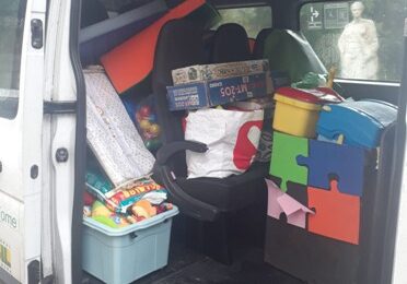 parte interior da van com caixas coloridas contendo brinquedos